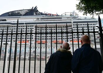 Asomados a la verja del muelle / FOTO: Eulogio García