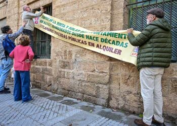 Colgando una pancarta reivindicativa en el antiguo ambulatorio / FOTO: Eulogio García